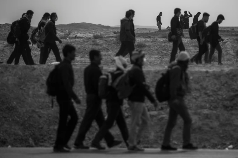 a black and white po of a bunch of people walking