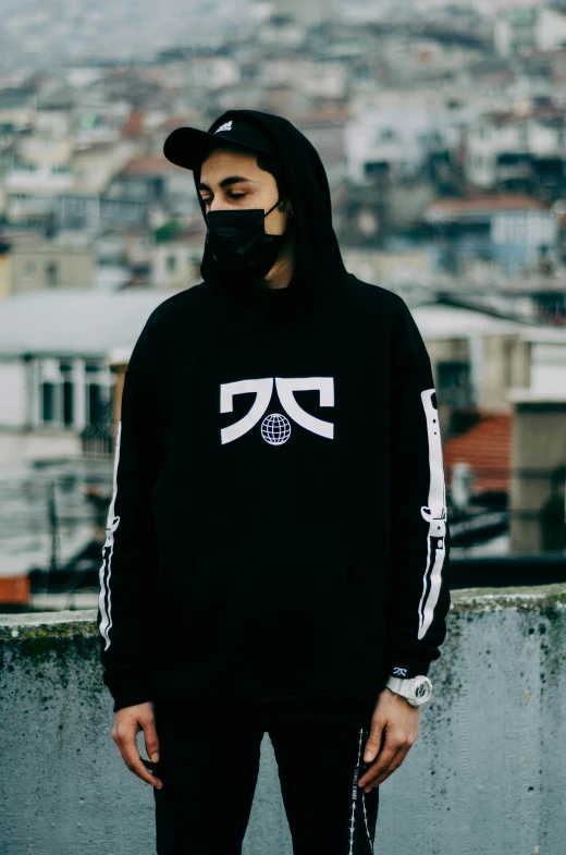 a young man is wearing a mask and hoodie