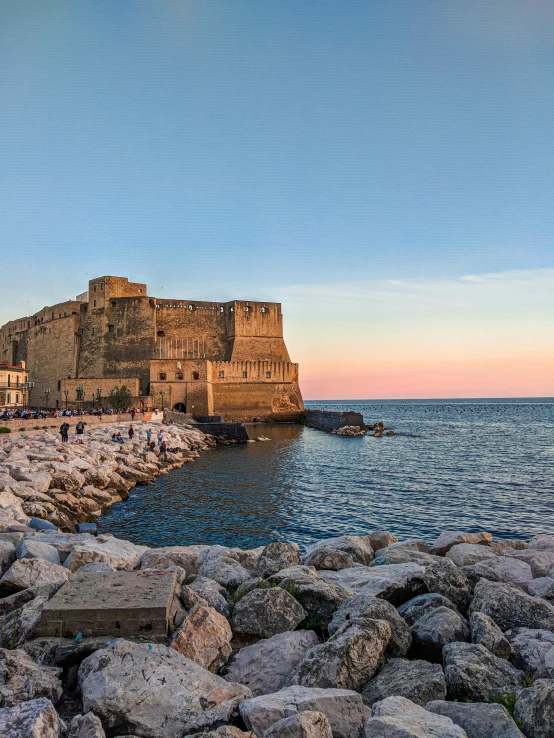 a rocky beach with a small building on top