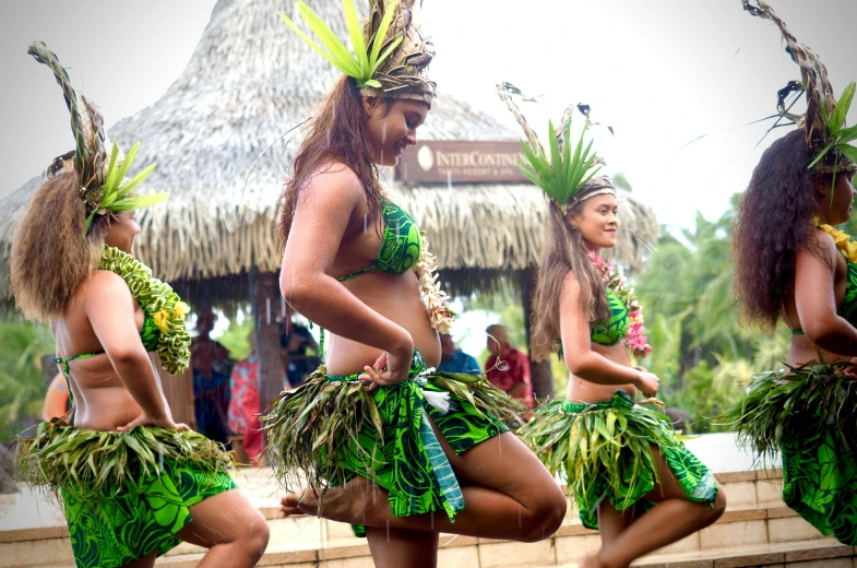 a group of s in green dresses dancing together