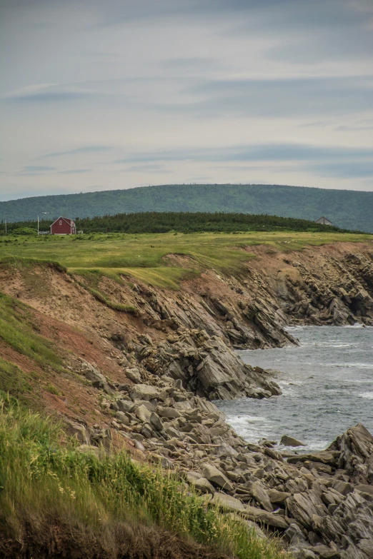 two red barns on a rocky shore by the ocean