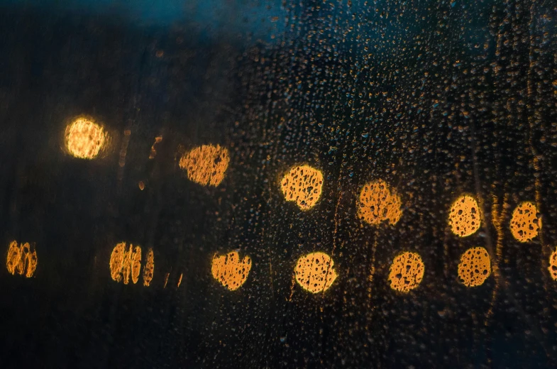 a picture through the rain covered window at a bus stop