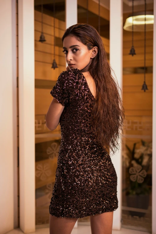 woman in short brown dress standing near the doorway