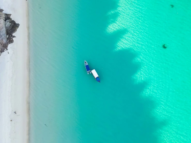 an aerial view of boats in the shallow water on a beach