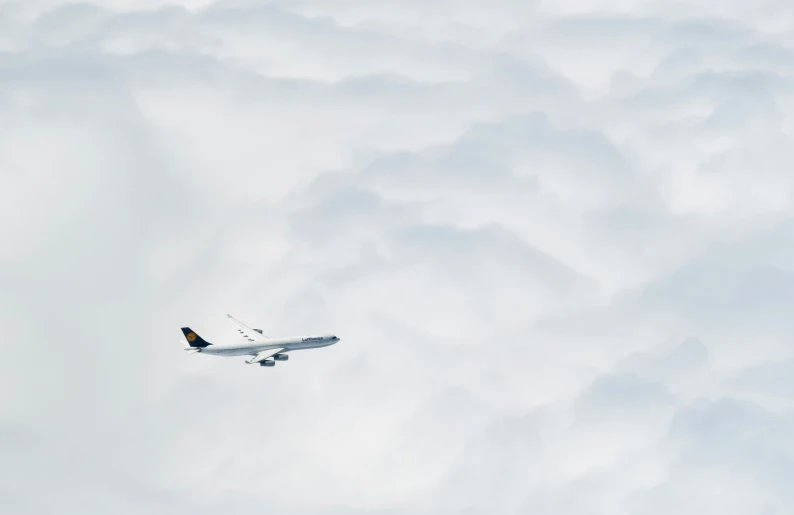 an airplane flying through the clouds in a bright blue sky
