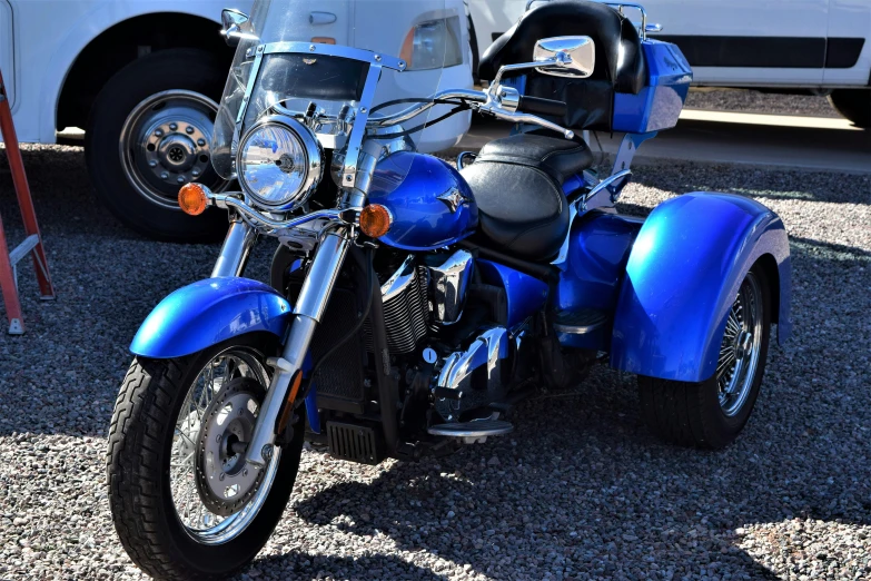 a blue motorcycle sits parked in the parking lot