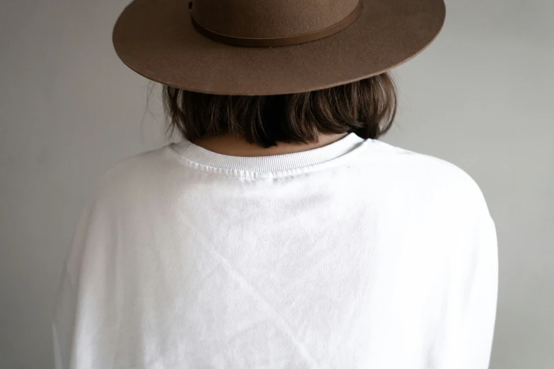 the rear view of a girl with a wide brimmed brown hat