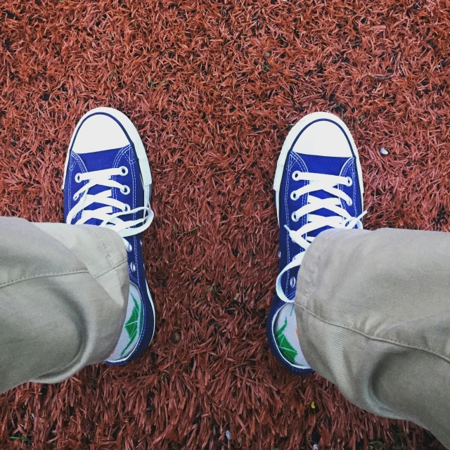 the feet of people wearing tennis shoes are seen on a carpet