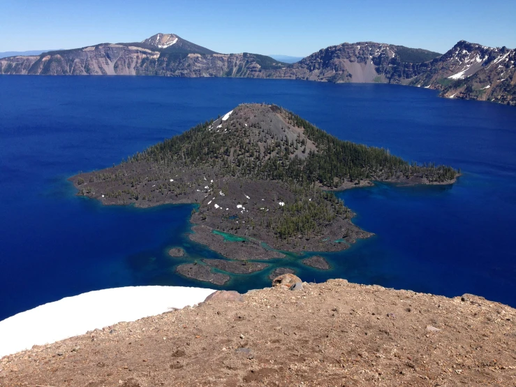 an island surrounded by large body of water in the middle of a mountain range