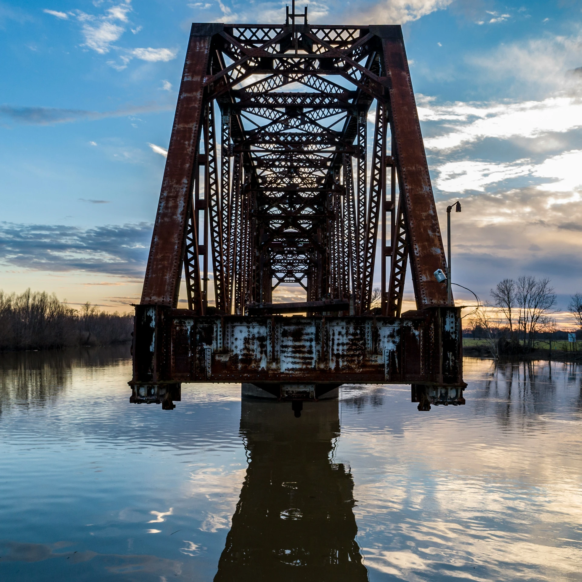 the silhouette of a train track over water