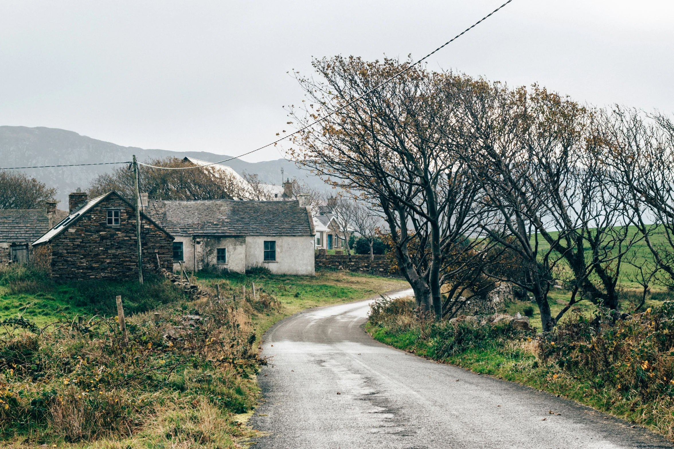 an old stone house and its road in the country