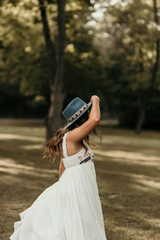 the back of a girl's head with her hat raised in the air