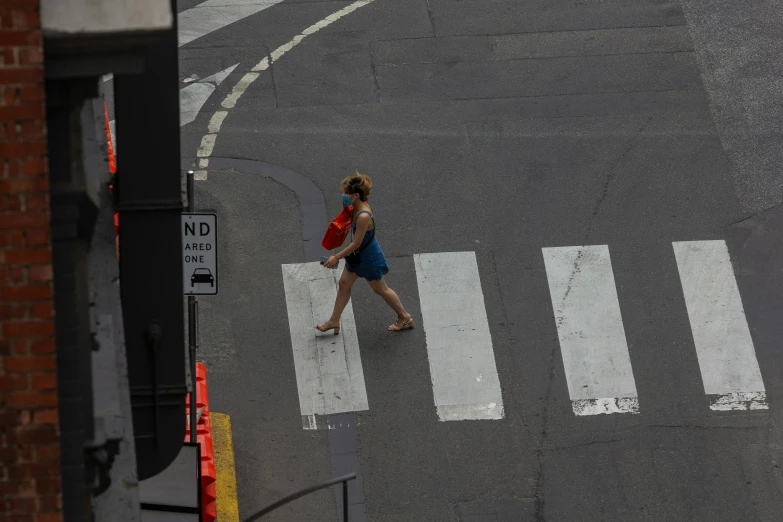 a woman crossing a street in the middle of an intersection