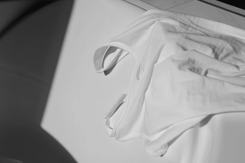 a white shirt sitting on top of a dryer