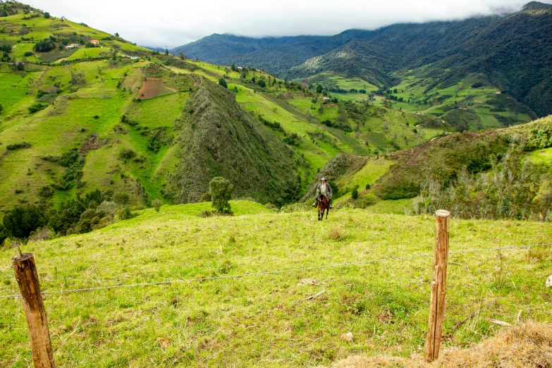 a person is riding a horse through a hilly area