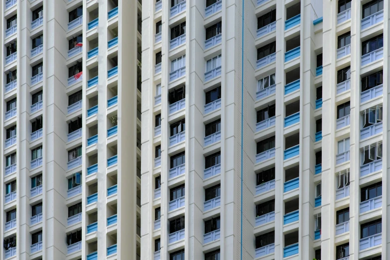 a tall white building that has blue and red balconies