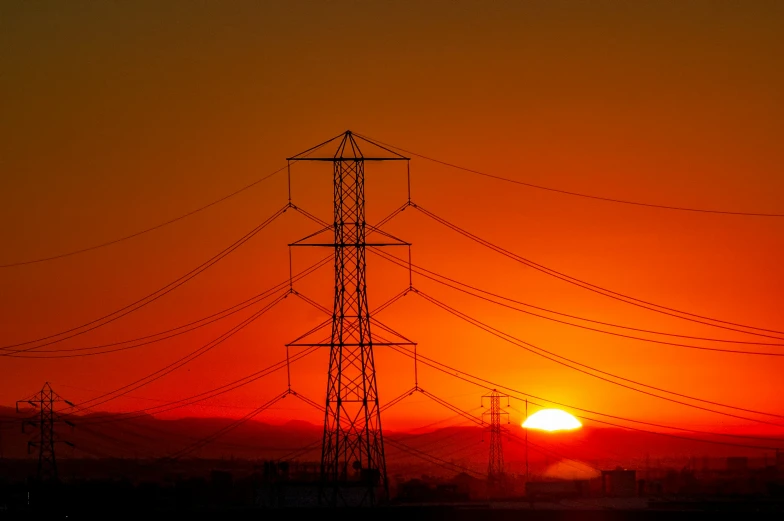 a sunset and power lines in the distance