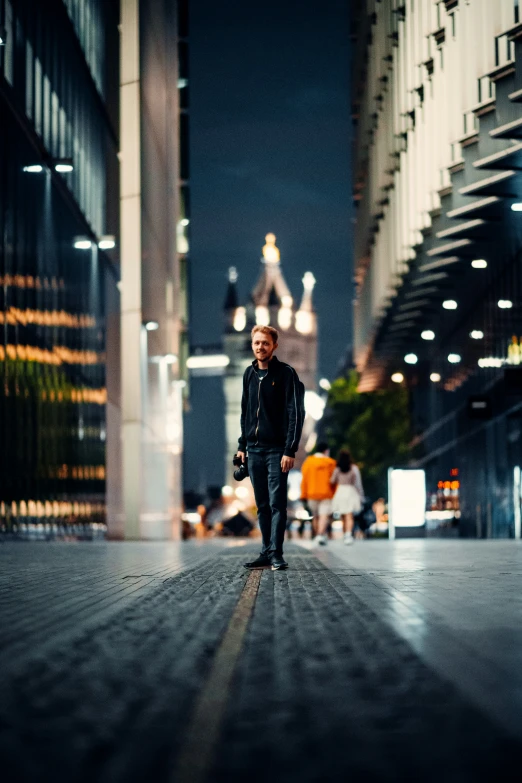 a man walking down a street next to tall buildings