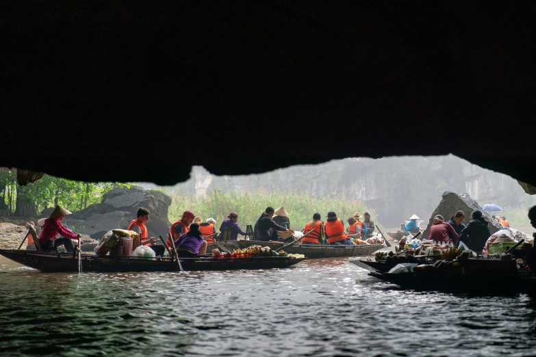 several boats with people in them floating through a river