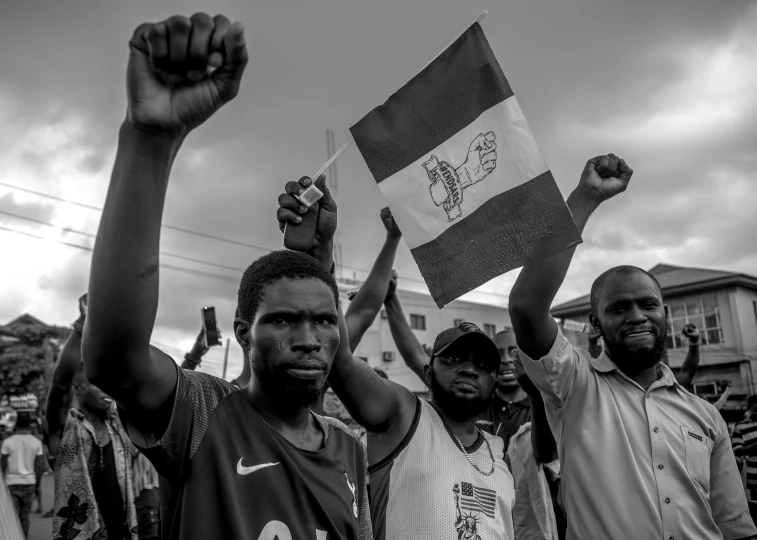 several people stand holding up their hands and the flag