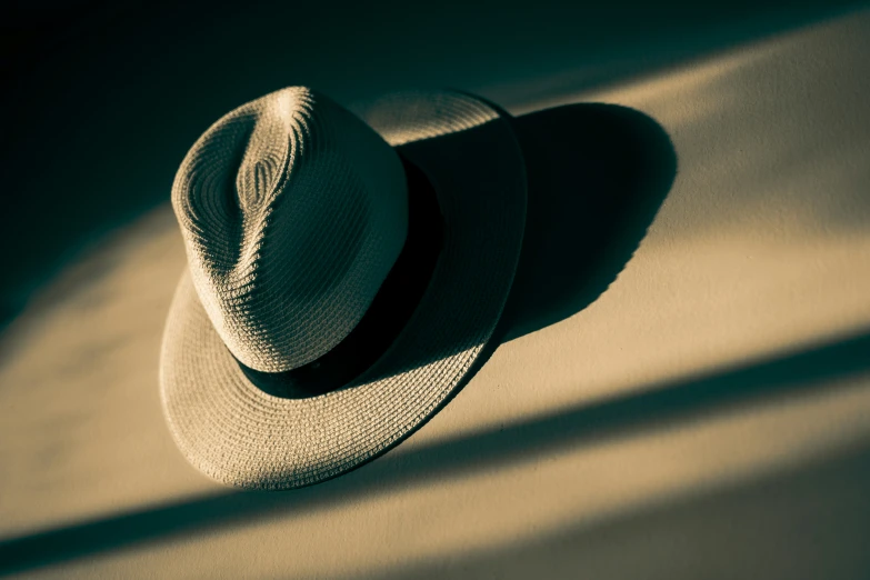 a hat laying on a floor with a shadow