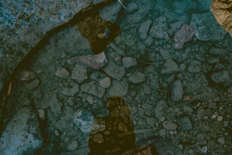 an aerial view of rocks and dirt on a river