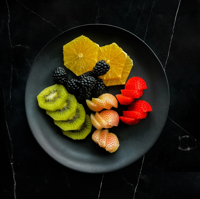 various kinds of fruit are on the black plate