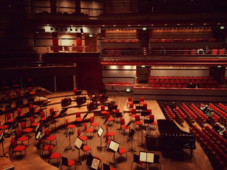 a large auditorium with multiple red and black chairs