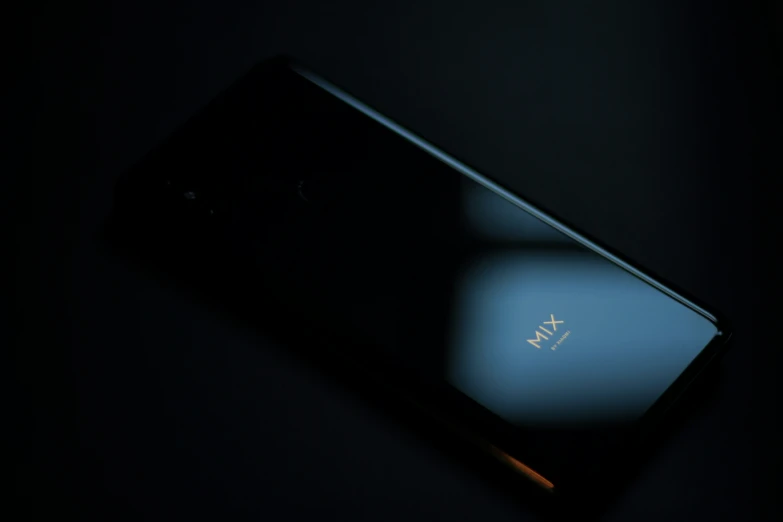 a smartphone sitting on top of a table next to a lamp