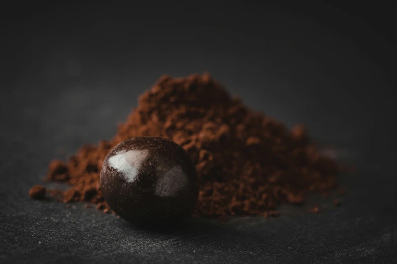 there is a chocolate truffle next to some red powder