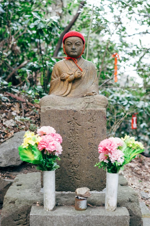 a large statue and flower arrangements on cement slab