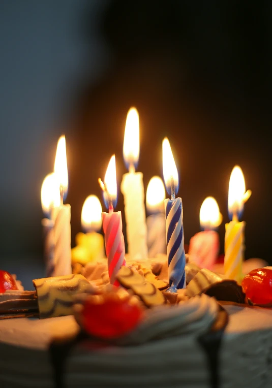 many lit candles are arranged on a white cake