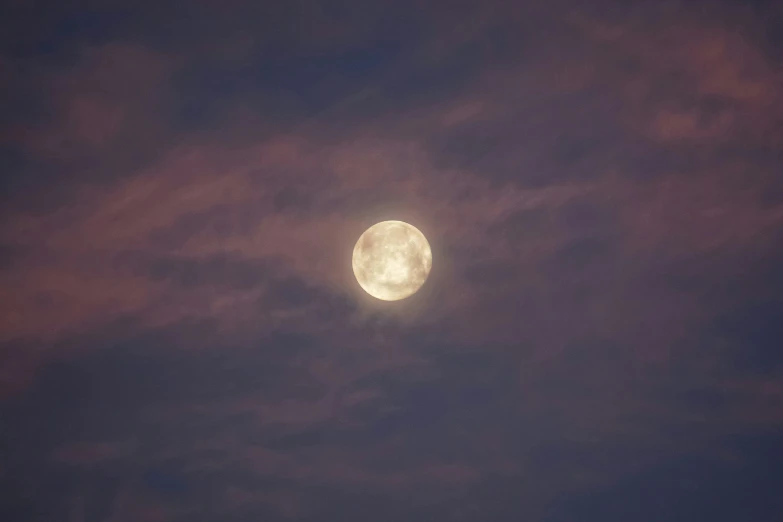 a large white moon in the sky during a dark night