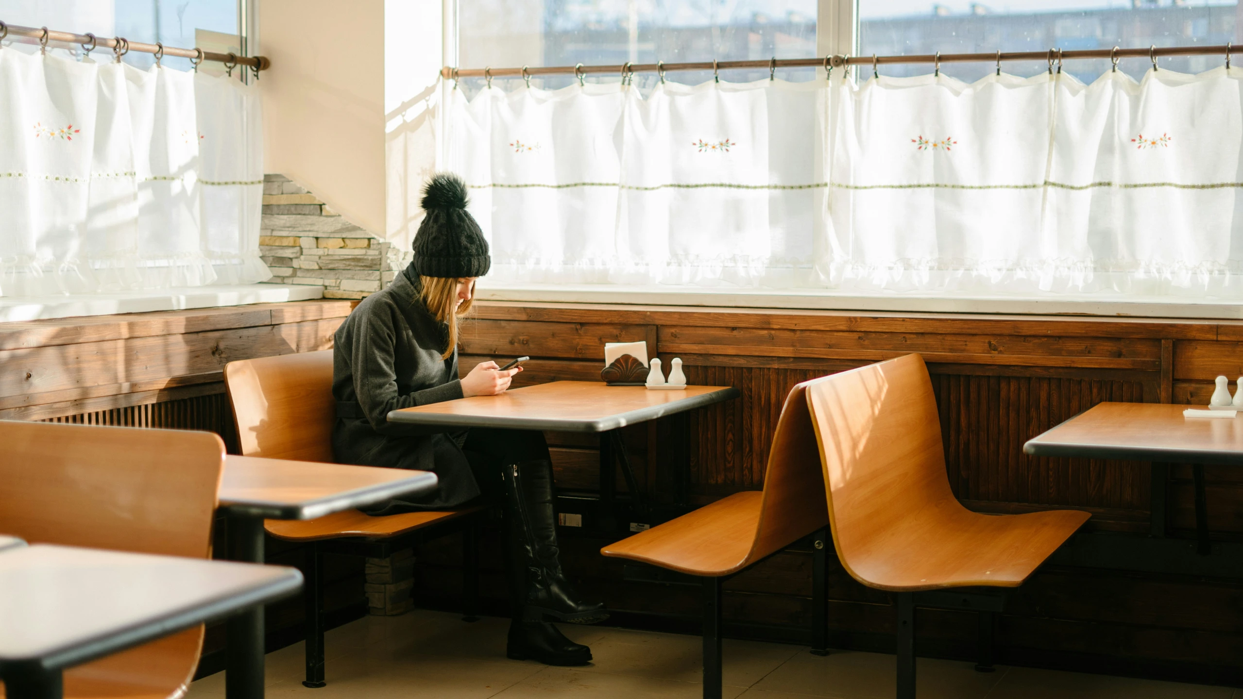 a man in a black hat sits in a diner