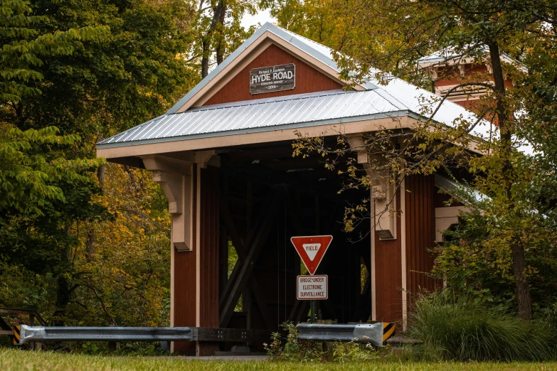 a small building with a sign and a road sign attached to it