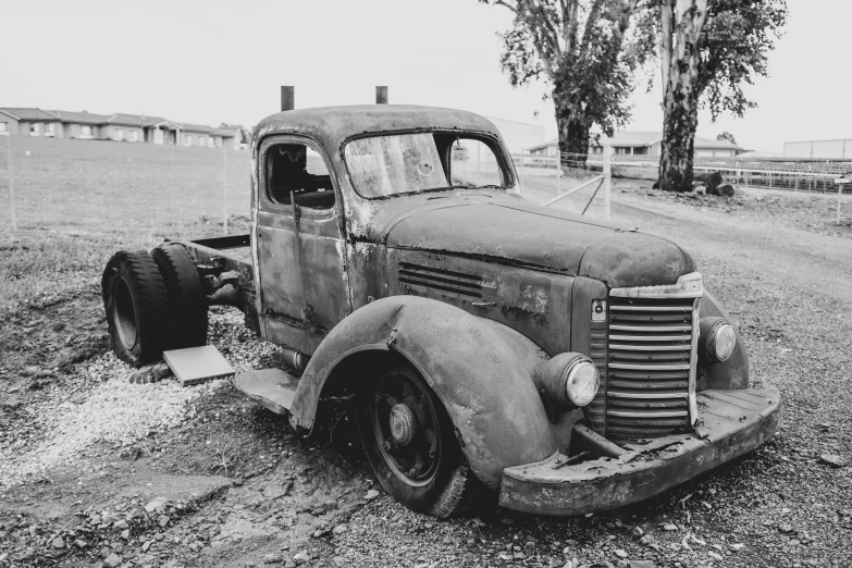 an old black and white pograph of an old rusted truck