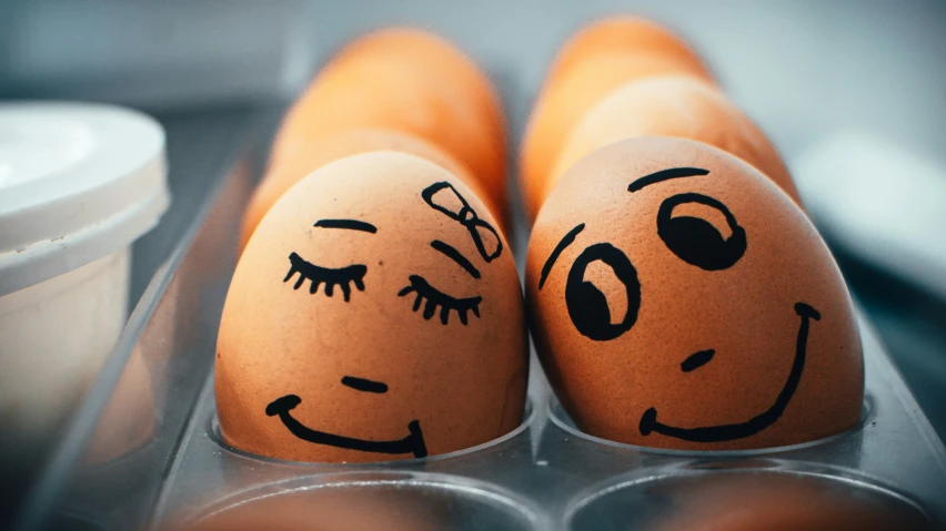 two brown eggs with faces drawn on them