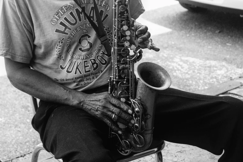 black and white pograph of a man holding a saxophone