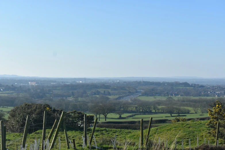 a grassy, field with several fences in front of a city