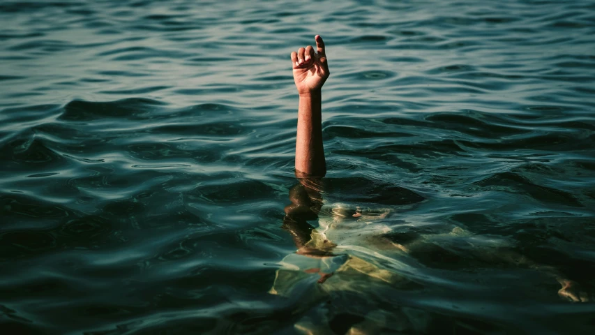 a person's hand above the water, as if in a flood