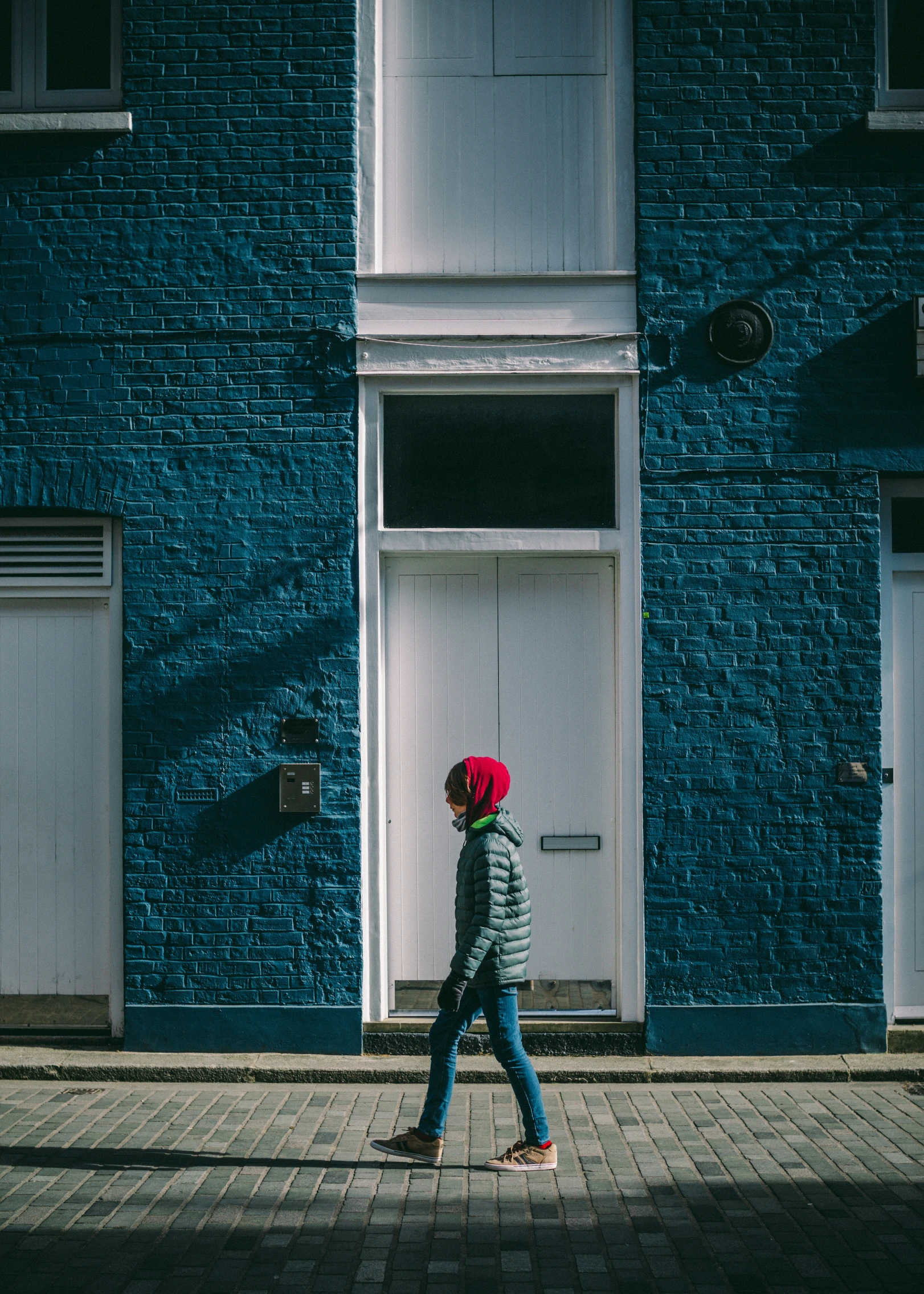 a person walking down the street with a red umbrella