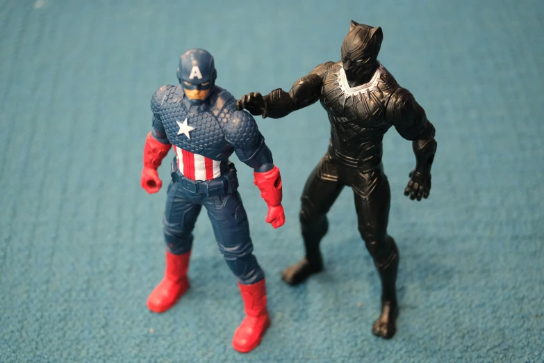 a toy figurine of two different kinds, two males with masks, one male has spider - man