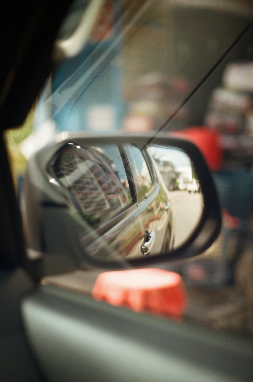 a side view mirror reflecting a car outside