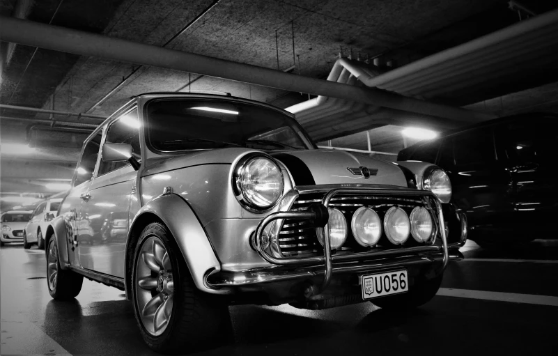 an old model mini car in a parking garage