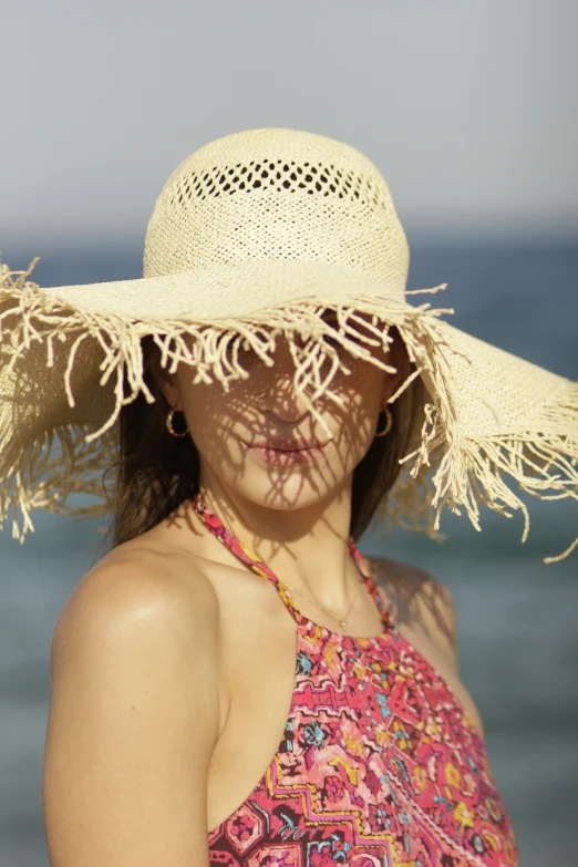 the woman is wearing a large hat with tassels on it