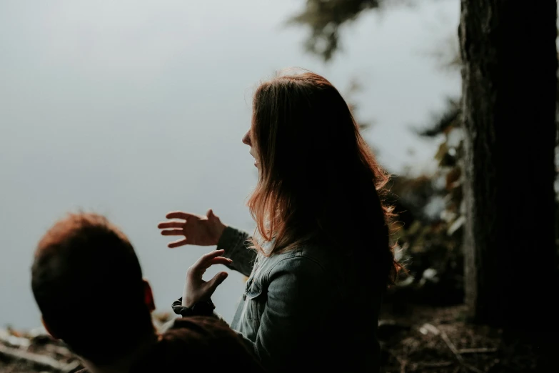 a woman and man standing by the lake