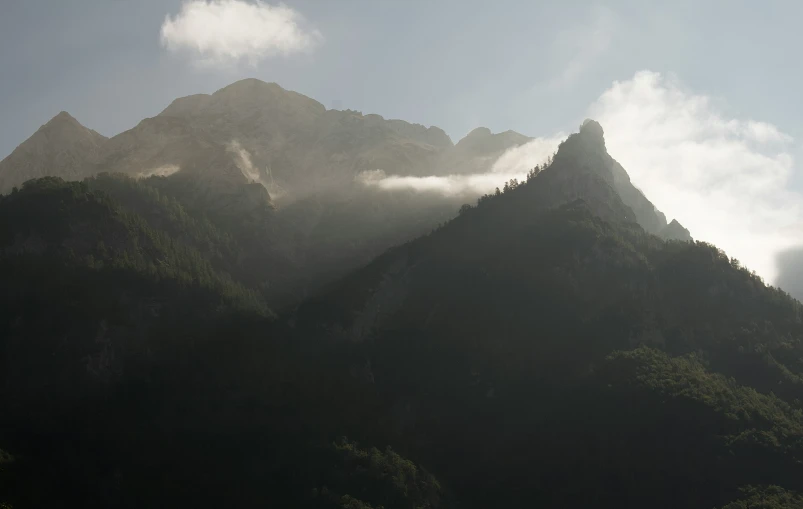 a large mountain range with clouds over it