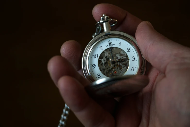 a person holding an open pocket watch in their hand