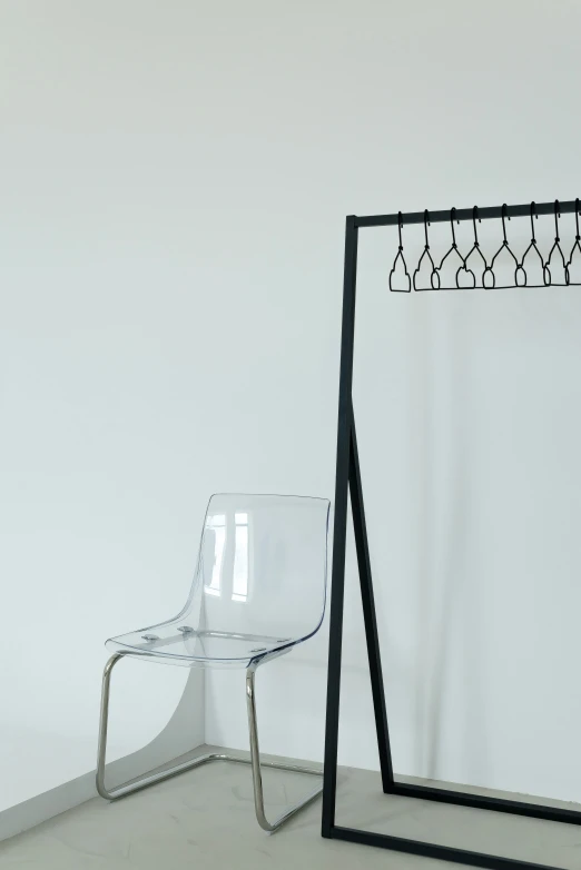 a glass chair and coat rack in a corner