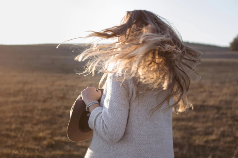 a woman with long hair in an open field